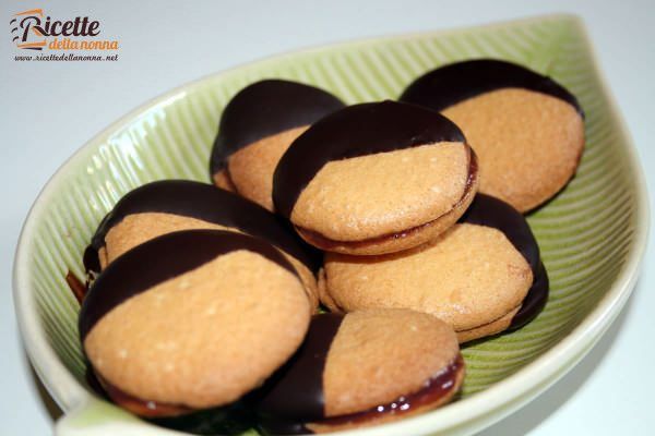 Biscotti glassati al cioccolato ripieni alla marmellata di melograno