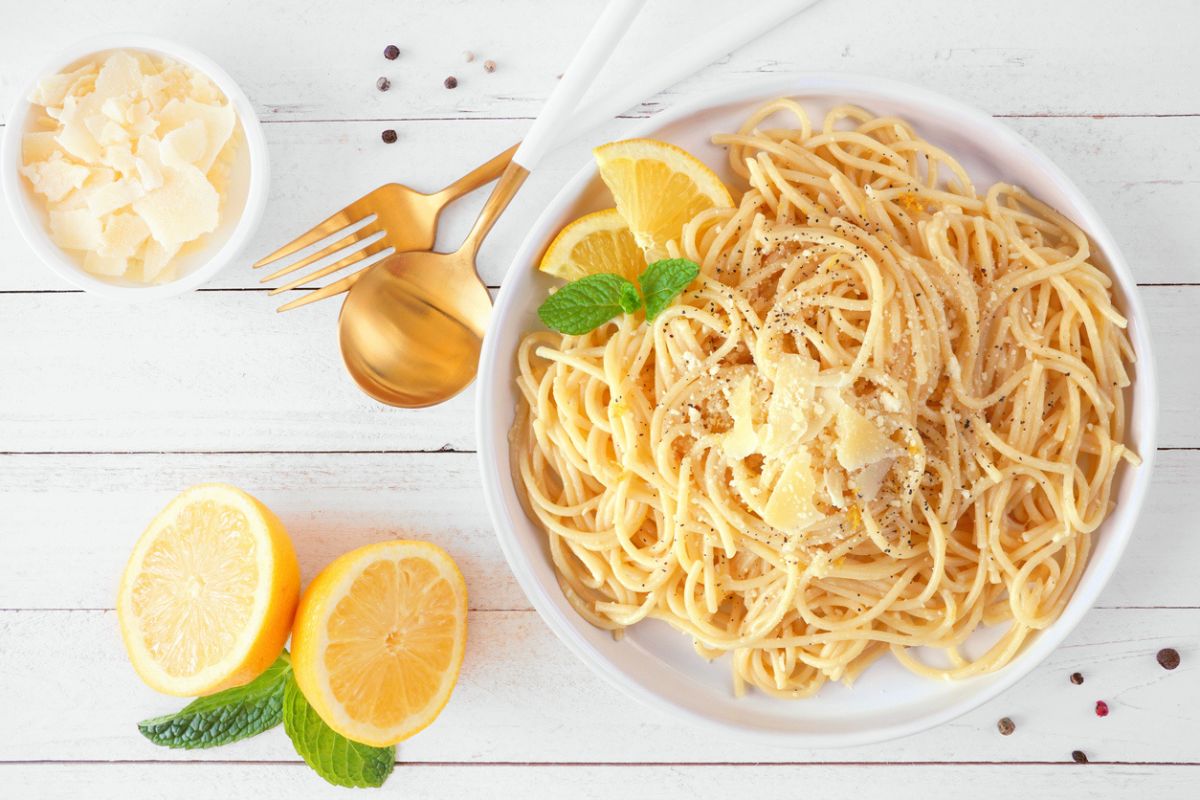 Spaghetti al limone e parmigiano, su una tavola di legno bianco