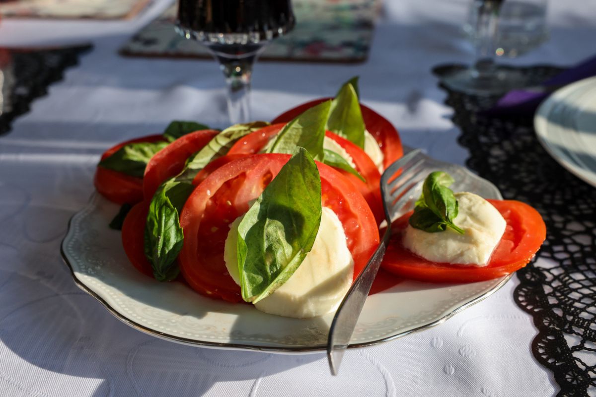 Insalata caprese su un piatto: pomodoro, mozzarella e basilico