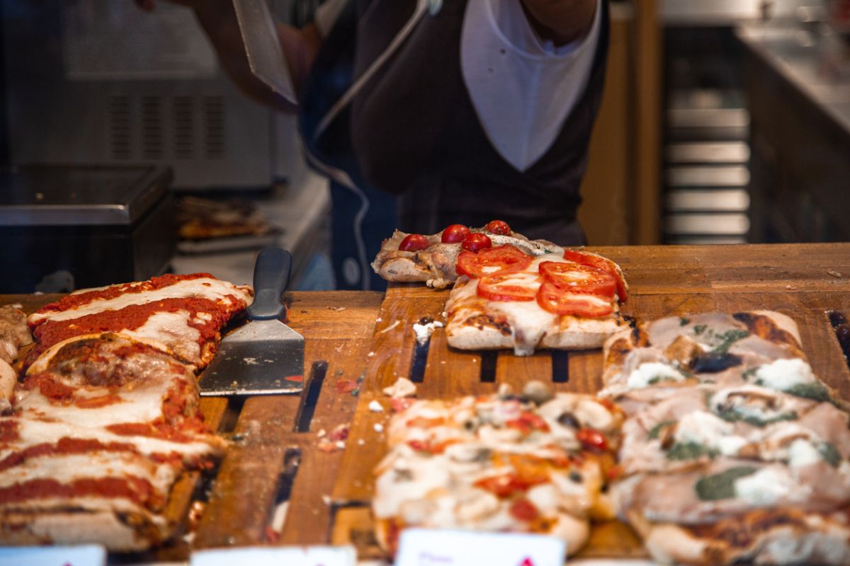 Pizza senza lievitazione, in una pizzeria al taglio. Pizza al taglio